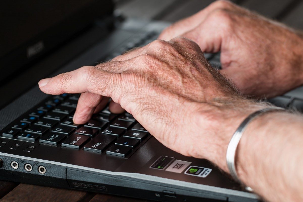 This is an image of a senior typing on a laptop's keyboard.